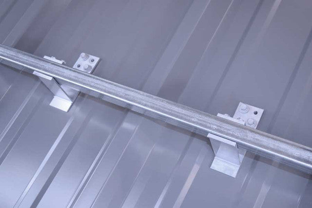 SnoBar screw-down snow rail installed on metal roof panel preventing snow slides